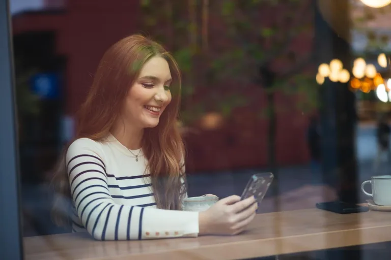 Logistyka | Studia I stopnia w Opolu | Uniwersytet WSB Merito Opole: Dziewczyna uśmiechająca się do telefonu