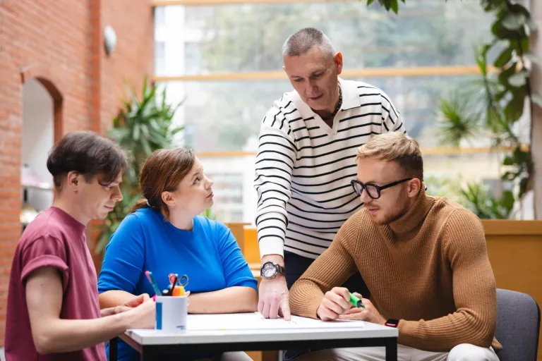Zarządzanie | Studia I stopnia w Opolu | Uniwersytet WSB Merito Opole: Grupa studentów pracująca nad projektem pod okiem wykładowcy