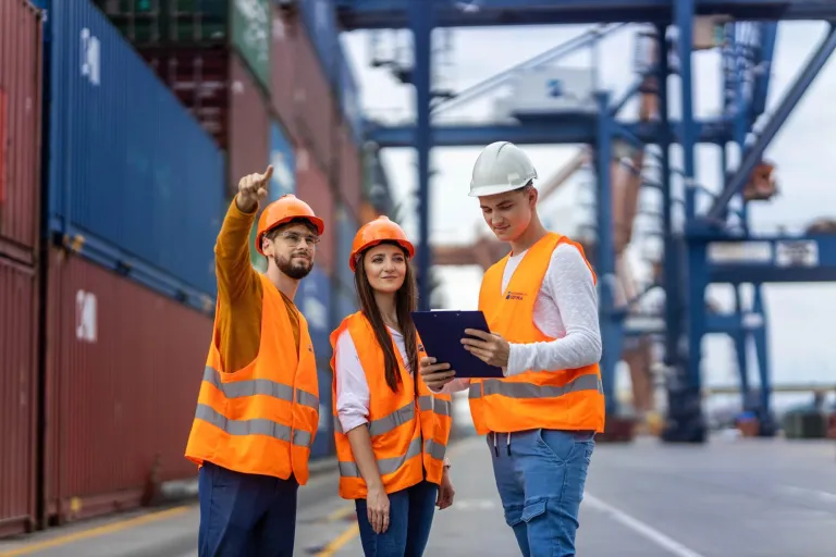 Przywództwo w logistyce | Studia I stopnia w Opolu | Uniwersytet WSB Merito Opole: Zdjęcie główne: Opole - logistyka: grupa młodych ludzi w kamizelkach odblaskowych ustala plan działania