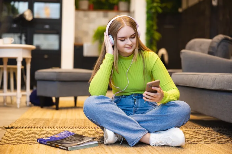 Pedagogika resocjalizacyjna z socjoterapią | Studia II stopnia ze studiami podyplomowymi  | Uniwersytet WSB Merito Opole: Kobieta słuchająca muzyki na słuchawkach