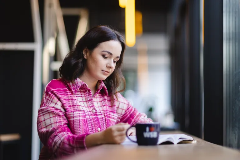 Wyniki wyszukiwania | Uniwersytet WSB Merito Opole: Studentka siedzi i czyta książkę