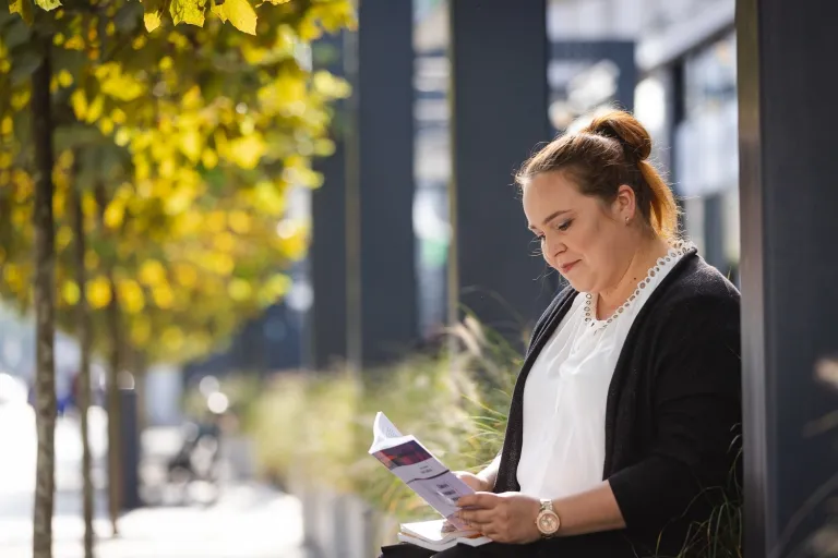 Programowanie | Uniwersytet WSB Merito Opole: Studentka siedzi i czyta książkę