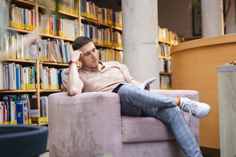 Sztuczna inteligencja i Data Science | Uniwersytet WSB Merito Opole: Student siedzi na fotelu i czyta książkę