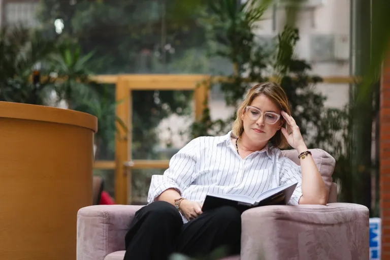 Inżynieria sieci, systemów i bezpieczeństwa IT | Uniwersytet WSB Merito Opole: Studentka siedzi na fotelu i czyta książkę