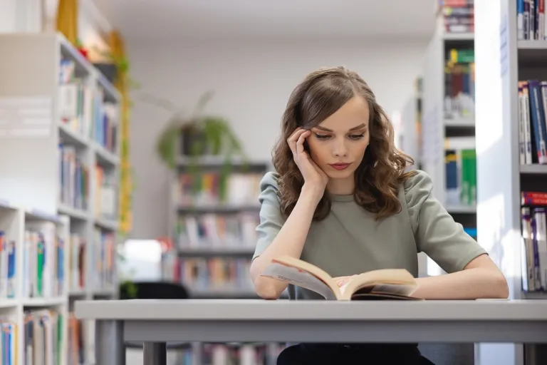 Dietetyka sportowa | Studia I stopnia w Opolu | Uniwersytet WSB Merito Opole: Studentka siedzi i czyta książkę