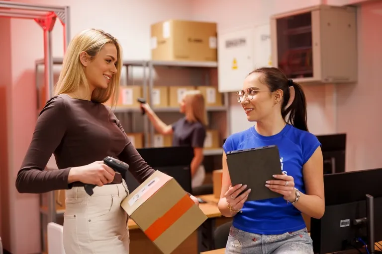 Logistyka i spedycja międzynarodowa | Studia I stopnia w Opolu | Uniwersytet WSB Merito Opole: Studentki rozmawiają przy skanowaniu paczek