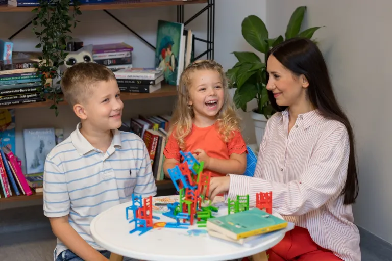Pedagogika przedszkolna i wczesnoszkolna - rekrutacja wystartuje już niebawem! | Aktualności | Uniwersytet WSB Merito Opole: Zdjęcie główne: Opole - kobieta rozmawia z dziećmi przy stoliku. Na stoliku leżą klocki.