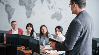 Coaching i mentoring – szkolenie z certyfikatem Franklin University (USA) | Szkolenia i kursy w Poznaniu | Uniwersytet WSB Merito w Poznaniu: Wykładowca prowadzi zajęcia w sali komputerowej przed grupą studentów