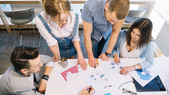 Przywództwo i delegowanie zadań – szkolenie z certyfikatem Franklin University (USA) | Szkolenia i kursy w Poznaniu | Uniwersytet WSB Merito w Poznaniu: Grupa osób wspólnie analizuje wykresy przy stole