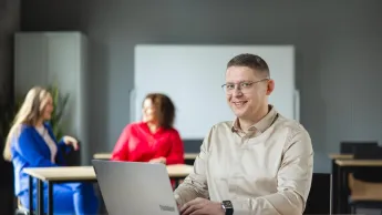 Bibliotekoznawstwo | Studia podyplomowe w Poznaniu | Uniwersytet WSB Merito w Poznaniu: Mężczyzna przy laptopie w sali wykładowej.
