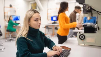 Narzędzia pracy menedżera | Studia I stopnia w Poznaniu | Uniwersytet WSB Merito w Poznaniu: Studentka pracuje przy komputerze w nowoczesnym laboratorium