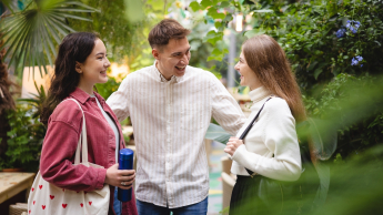 Psychologia w biznesie | Studia II stopnia ze studiami podyplomowymi w Poznaniu | Uniwersytet WSB Merito w Poznaniu: Student i 2 studentki rozmawiają w parku 