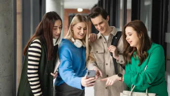 Bankowość | Uniwersytet WSB Merito w Poznaniu: Grupa studentów oglądających nagranie na telefonie.