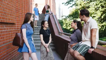 Manager bezpieczeństwa biznesu | Studia I stopnia w Poznaniu | Uniwersytet WSB Merito w Poznaniu: Grupa studentów rozmawiających na schodach starego browaru