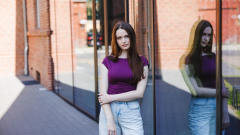 Psychodietetyka i poradnictwo zdrowego stylu życia | Studia I stopnia w Poznaniu | Uniwersytet WSB Merito w Poznaniu: Studentka pozująca do zdjęcia przed nowoczesnym budynkiem uczelni.