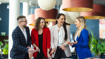 Mentor Foundation | Szkolenia i kursy w Poznaniu | Uniwersytet WSB Merito w Poznaniu: studenci stojący przy biurku