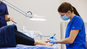 kobiety wykonują zabiegi podologiczne w gabinecie