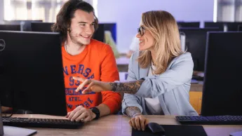 Handel międzynarodowy | Studia I stopnia w Poznaniu | Uniwersytet WSB Merito w Poznaniu: dwie osoby rozmawiają przy laptopie