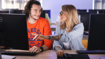 dwie osoby rozmawiają przy laptopie