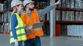 Logistyka | Studia I stopnia w Poznaniu | Uniwersytet WSB Merito w Poznaniu: kobieta i mężczyzna w kamilelkach odblaskowych i kaskach ochronnych