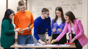 Bezpieczeństwo wewnętrzne | Studia I stopnia w Poznaniu | Uniwersytet WSB Merito w Poznaniu: Grupa studentów wspólnie pracuje nad materiałami przy stole