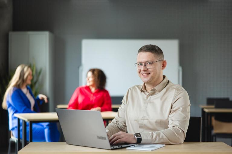 Program Firma | Uniwersytet WSB Merito w Poznaniu: Mężczyzna przy laptopie w sali wykładowej.