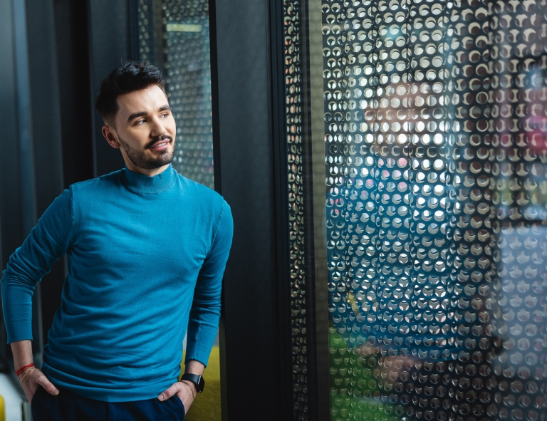 Tworzenie aplikacji internetowych i mobilnych | Studia podyplomowe w Poznaniu | Uniwersytet WSB Merito w Poznaniu: Główna grafika: Poznań - studia podyplomowe - Uczestnicy studiów podyplomowych podczas sesji zdjęciowej patrząc przez okno