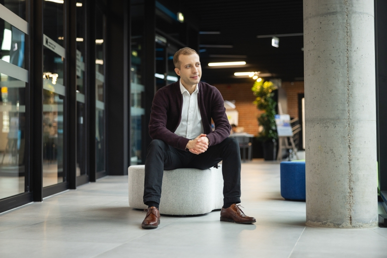 Studia MBA i EMBA w Poznaniu | Uniwersytet WSB Merito w Poznaniu: uczestnik MBA pozuje do zdjęcia na korytarzu uczelni- Uniwersytet WSB Merito POznań