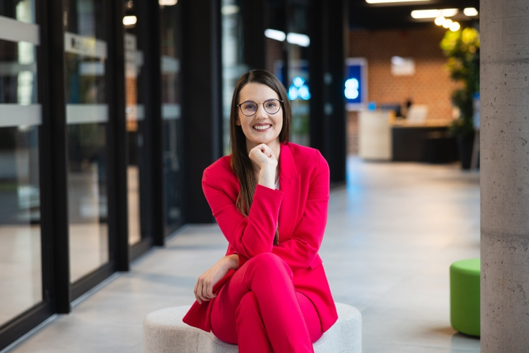 Studia MBA i EMBA w Poznaniu | Uniwersytet WSB Merito w Poznaniu: Uczestniczka MBA pozuje do zdjęcia na korytarzu uczelni- Uniwersytet WSB Merito Poznań