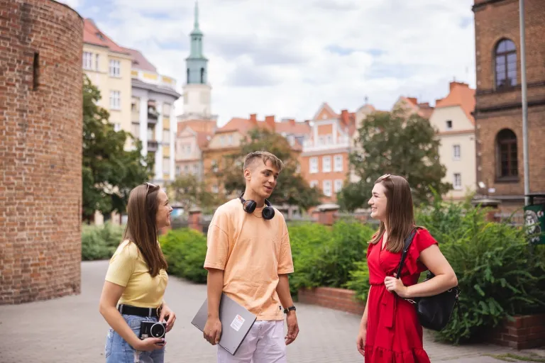 Zarządzanie marketingowe | Studia II stopnia ze studiami podyplomowymi  | Uniwersytet WSB Merito w Poznaniu: 2 dziewczyny i chłopak rozmawiają w centrum miasta Poznania