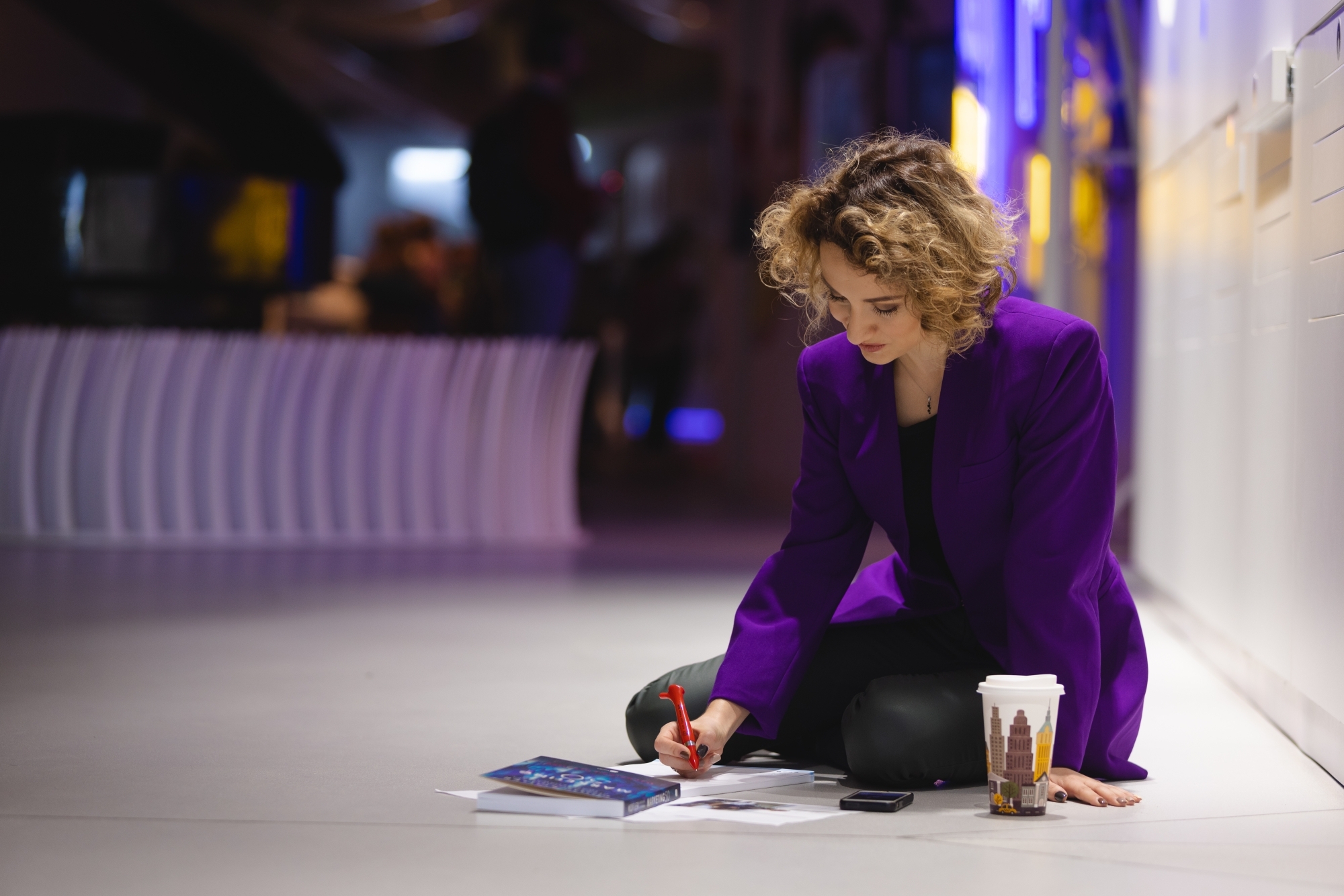 Dziewczyna siedząca na ziemi i czytająca gazetę