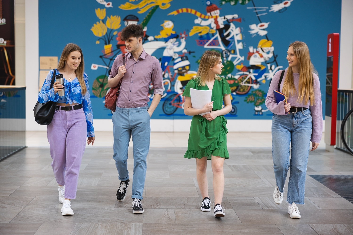 Grupa czterech osób rozmawiająca na korytarzu