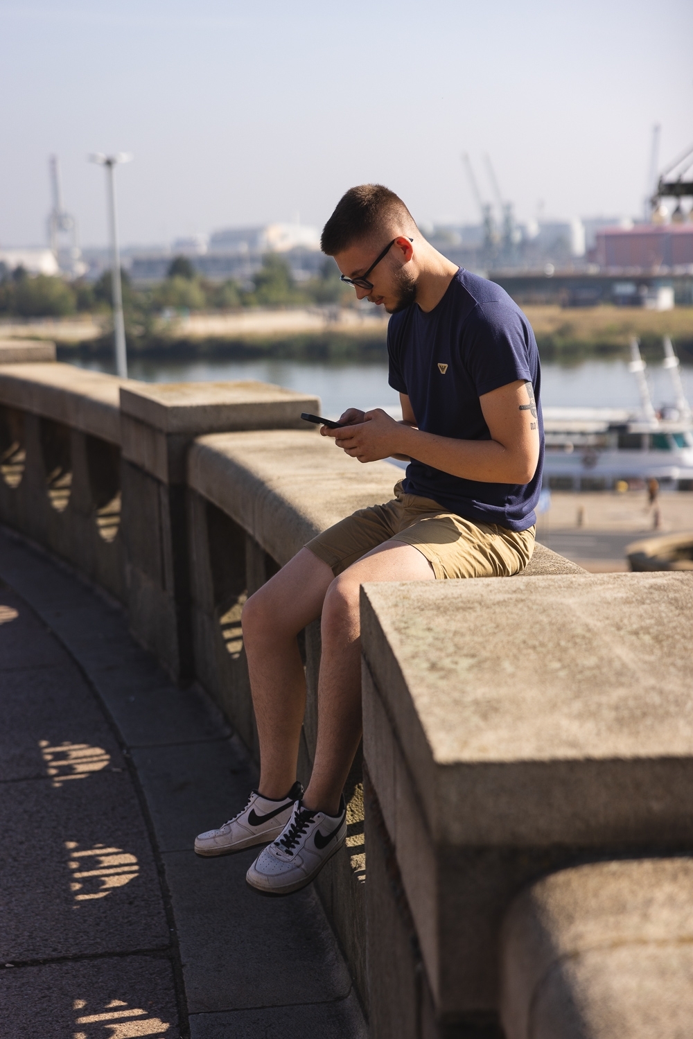 Mężczyzna znajdujący się na świeżym powietrzu, siedzący na murze