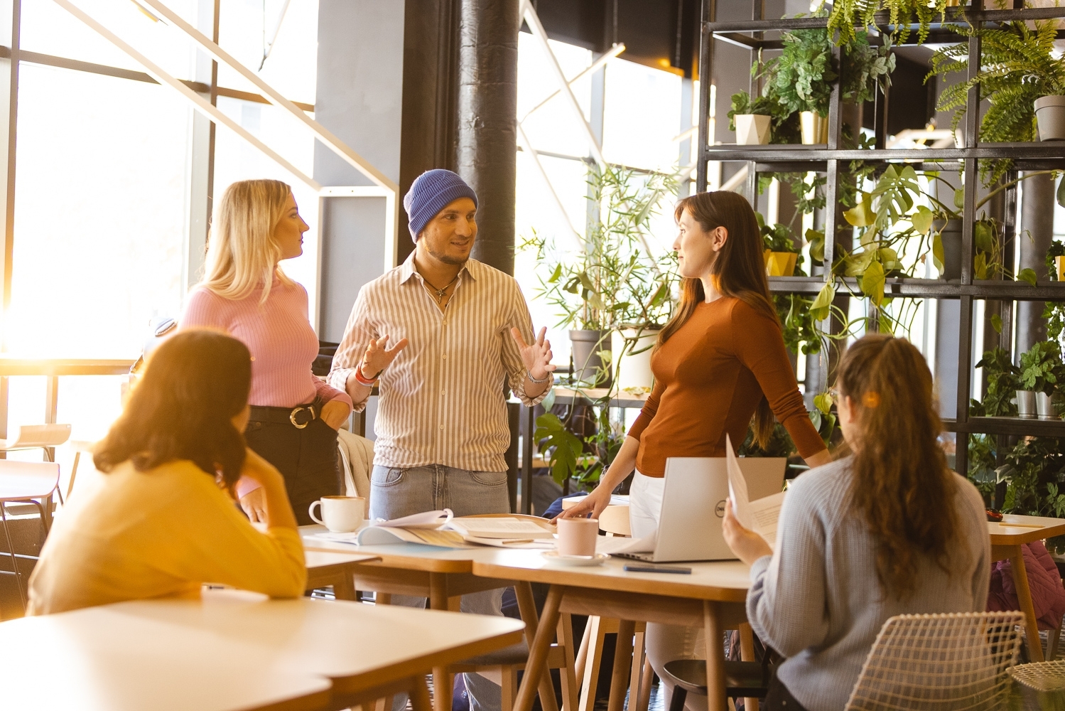 Grupa ludzi rozmawiająca w jasnym pomieszczeniu