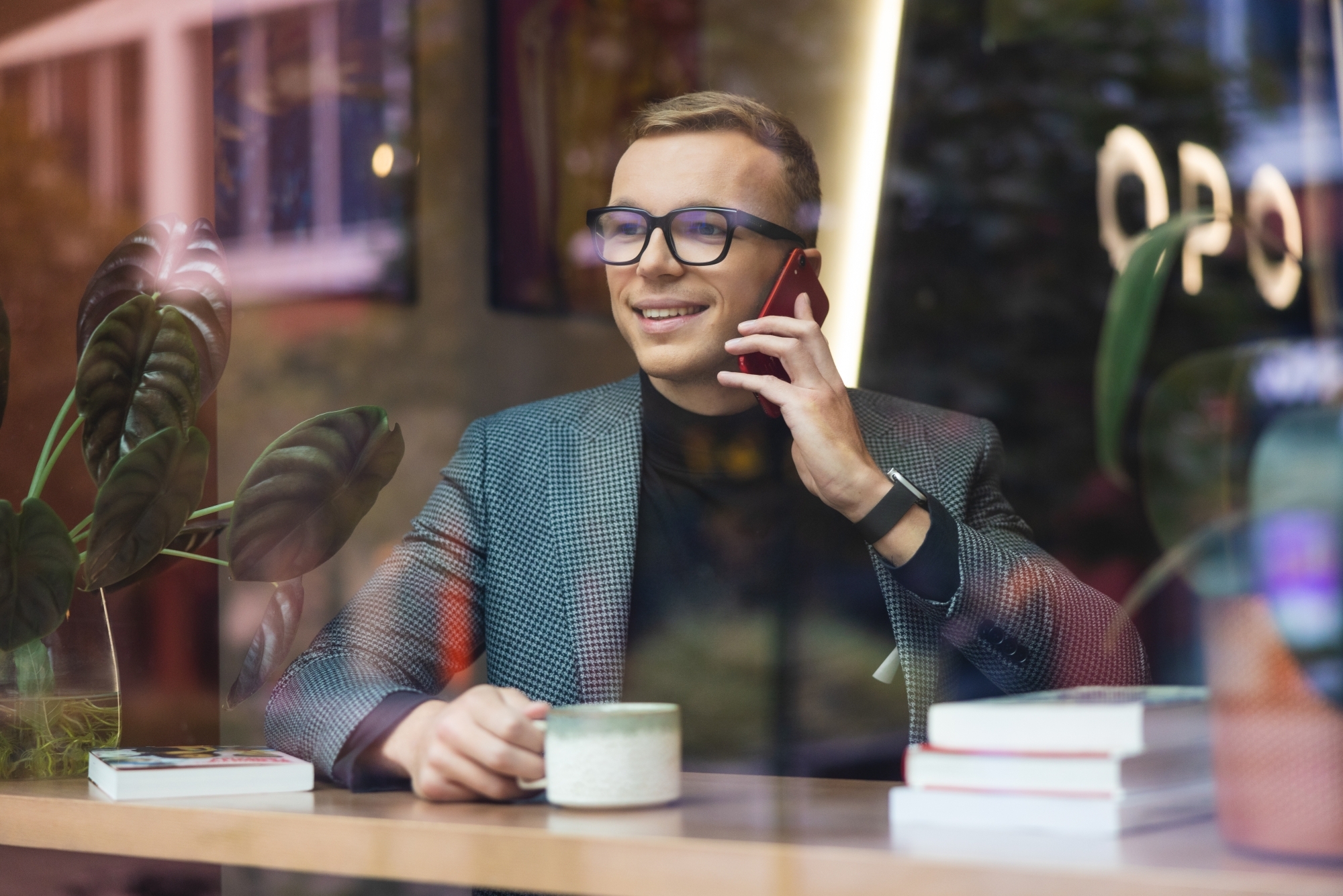 Mężczyzna rozmawiający przez telefon, wpatrujący się w okno