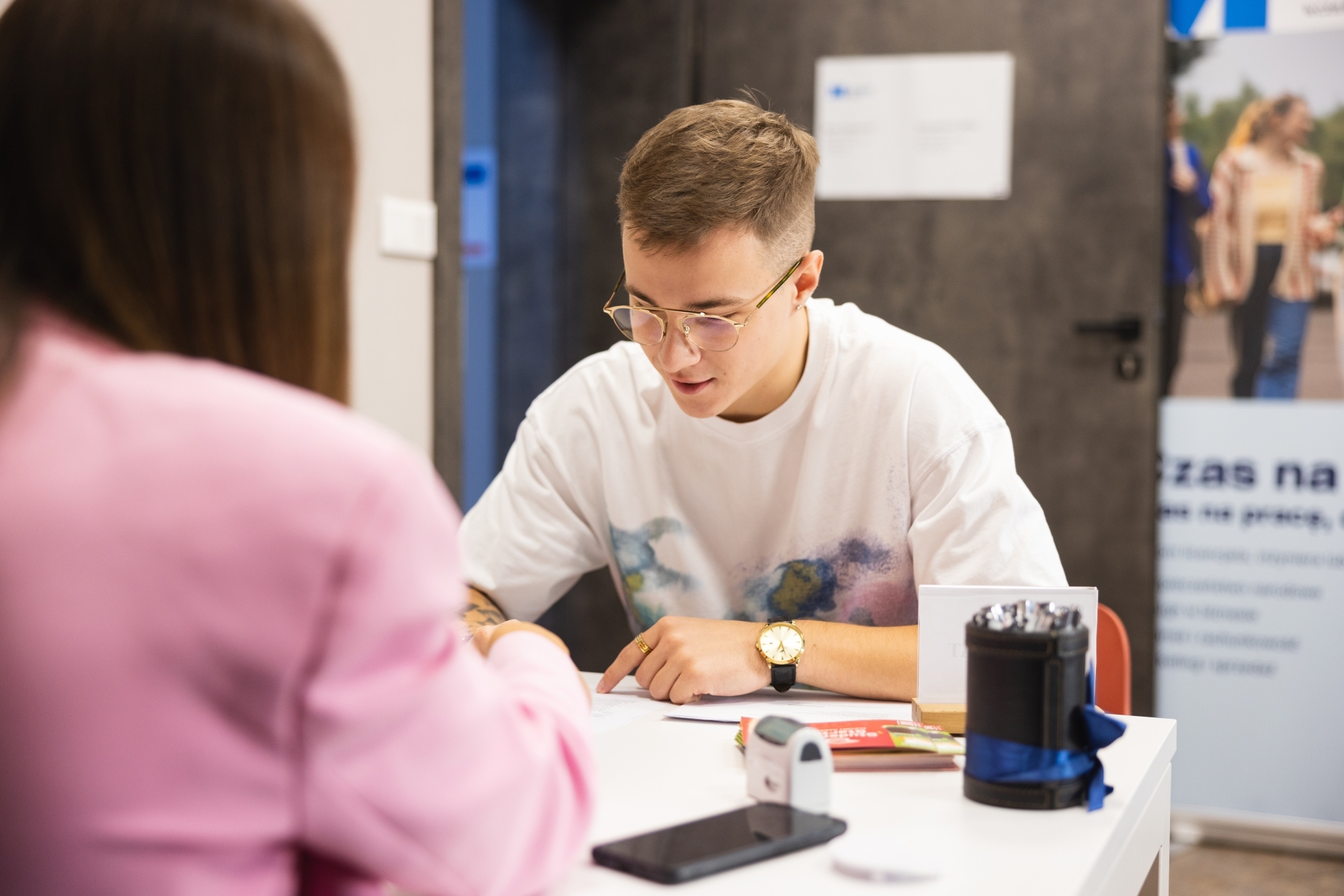 Mężczyzna przy biurku, wypełniający dokumenty