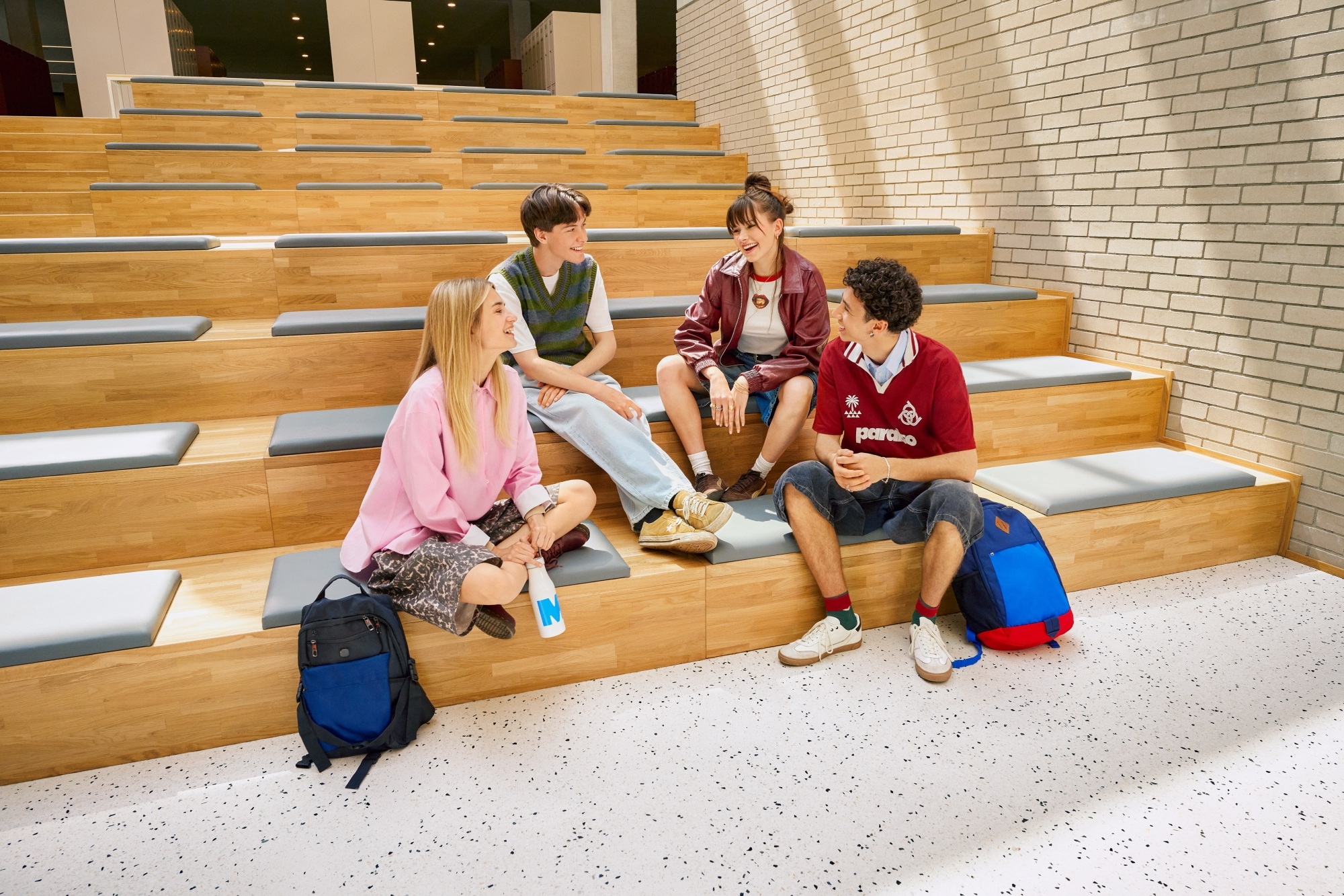 Czterech studentów siedzi na schodach