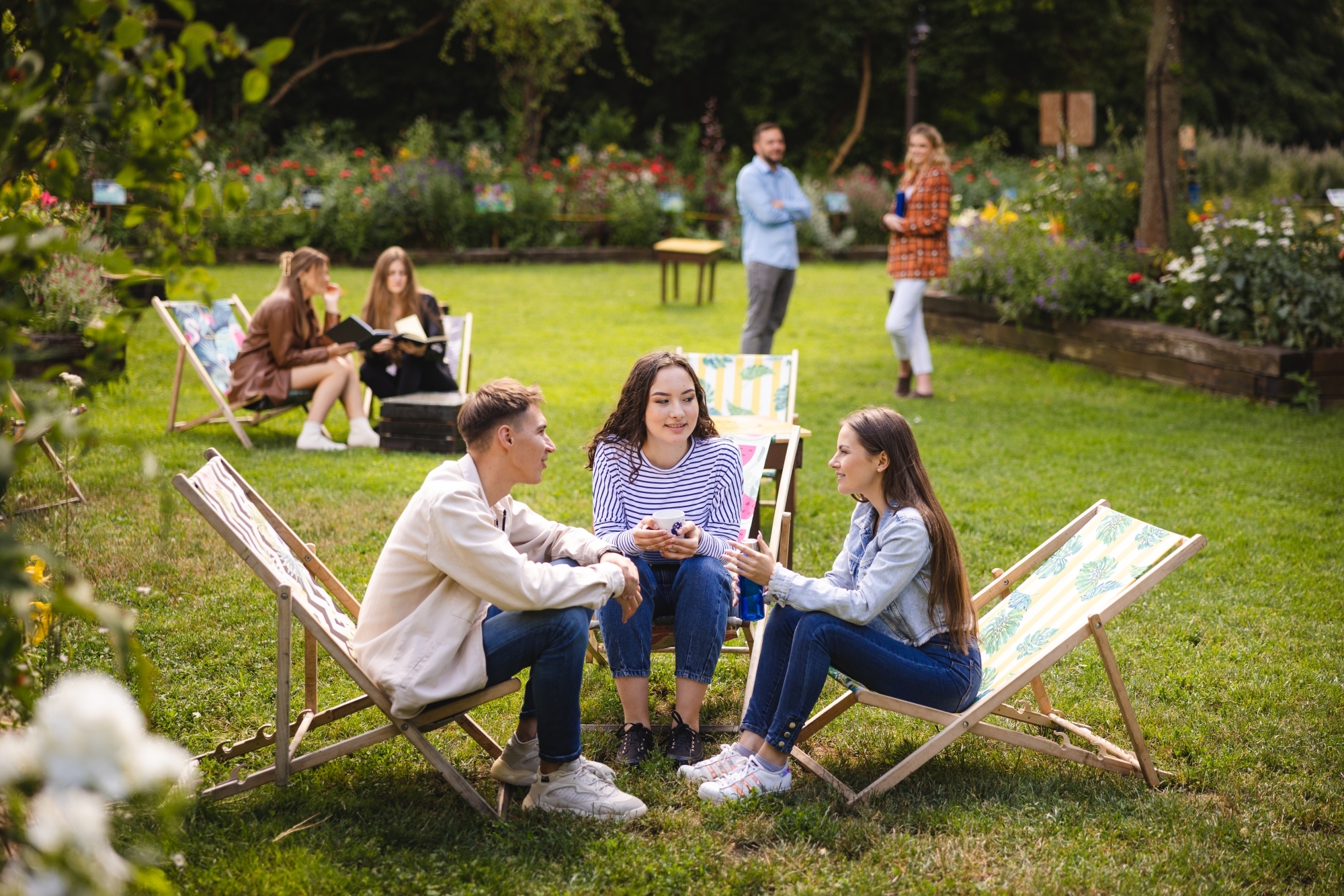 Młodzi ludzie siedzący na leżakach na dworze