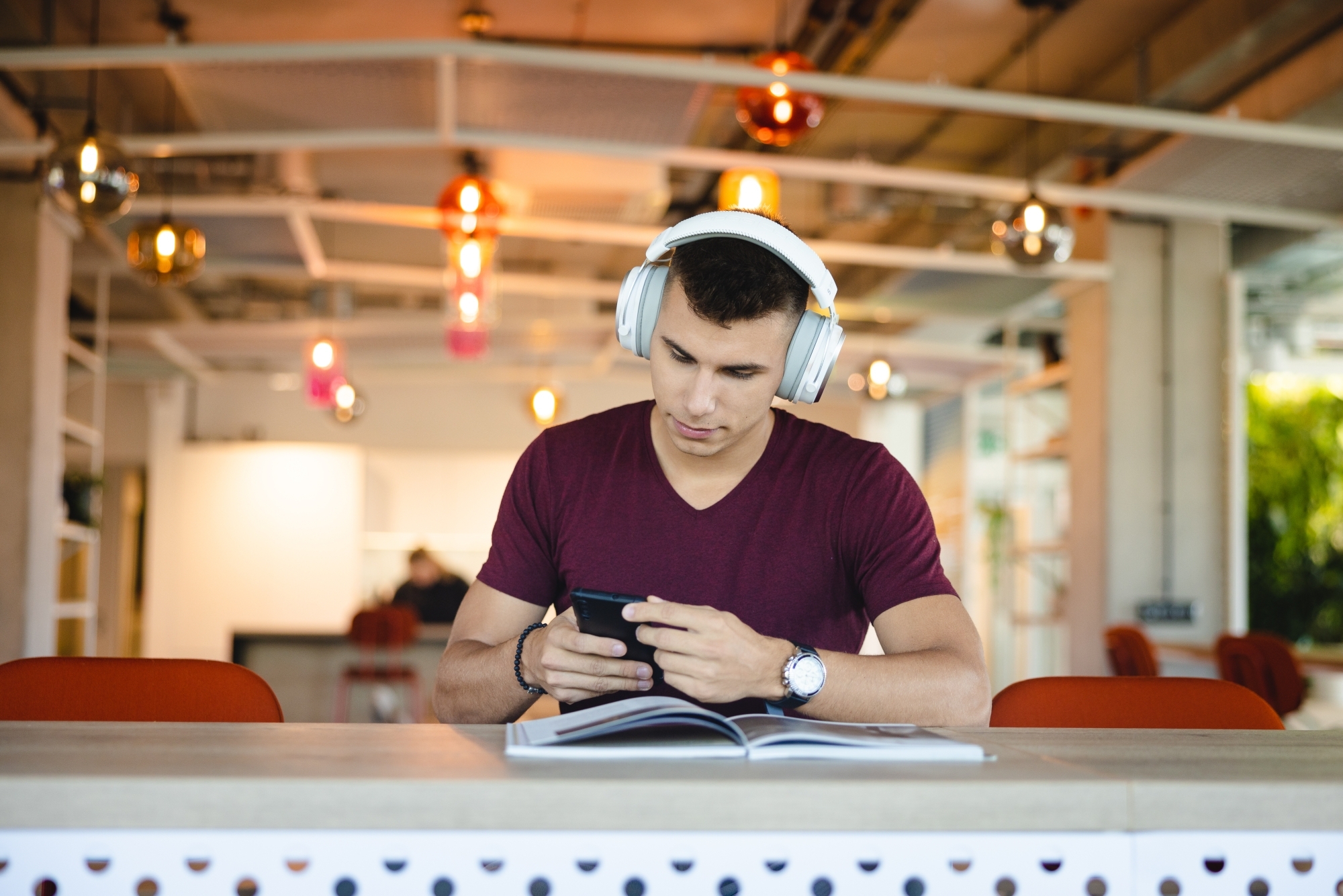 Chłopak w słuchawkach z książką w dłoni