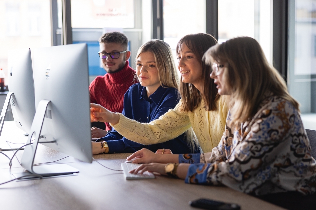 Grupa studentów przed monitorem komputera