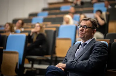 Sustainable and Socially Responsible Development in the Network of Socioeconomic Relations | Uniwersytet WSB Merito: Maciej Kolasiński słuchający wykładu z lekkim uśmiechem