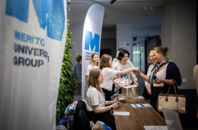 Sustainable and Socially Responsible Development in the Network of Socioeconomic Relations | Uniwersytet WSB Merito: Grupa studentek przy stoliku podczas rejestracji uczestników konferencji