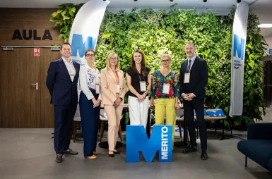 Sustainable and Socially Responsible Development in the Network of Socioeconomic Relations | Uniwersytet WSB Merito: Zdjęcie grupy prelegentów przed aulą wraz z logotypem Merito