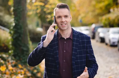 Blog "Okiem Praktyków" | Uniwersytet WSB Merito: Mężczyzna rozmawiający przez telefon na dworze