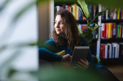 Poradniki - dzielimy się wiedzą | Uniwersytet WSB Merito: Dziewczyna z książką zapatrzona w okno