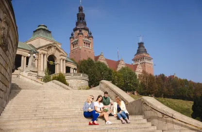 Blog "Okiem Praktyków" | Uniwersytet WSB Merito: Grupa ludzi rozmawiająca na schodach na świeżym powietrzu