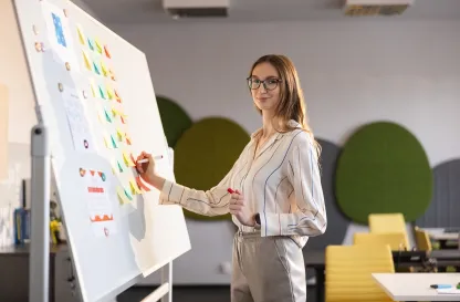 Poradniki - dzielimy się wiedzą | Uniwersytet WSB Merito: Grafika_główna_kobieta_pisząca_na_tablicy