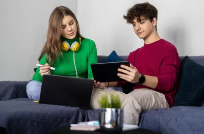 Blog "Okiem Praktyków" | Uniwersytet WSB Merito: Dwoje młodych ludzi siedzących na kanapie pracujących.