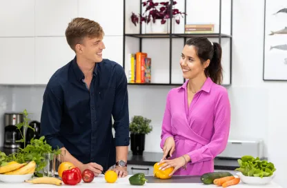 Blog "Okiem Praktyków" | Uniwersytet WSB Merito: Dwie osoby rozmawiające przy stole z warzywami