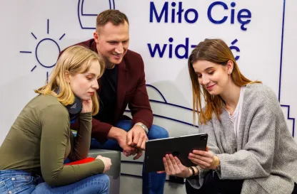 Blog "Okiem Praktyków" | Uniwersytet WSB Merito: Troje młodych ludzi wpatrujących się w tableta